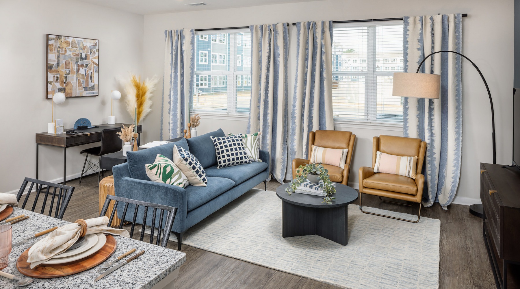 Resident lounge at Prose New Hope Apartments for rent in Raleigh, NC, featuring couches and large windows.